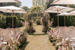 Provence wedding ceremony floral setup with sun umbrellas for guest shade